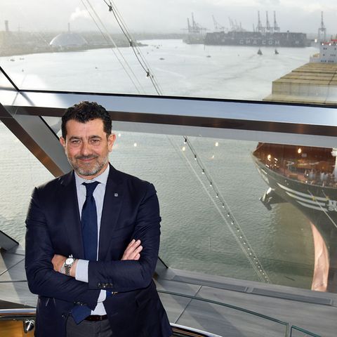 Mit einem MSC Containerschiff im Rücken: Gianni Onorato im Yacht Club der "MSC Bellissima". Der Italiener leitet als Chief Executive Officer das Unternehmen MSC Cruises seit 2013.