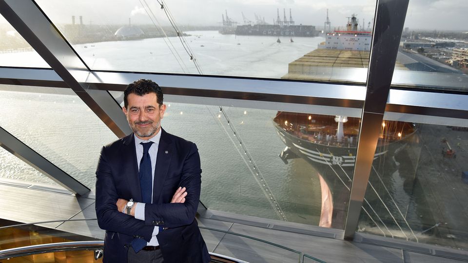 Mit einem MSC Containerschiff im Rücken: Gianni Onorato im Yacht Club der "MSC Bellissima". Der Italiener leitet als Chief Executive Officer das Unternehmen MSC Cruises seit 2013.