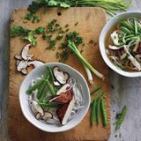 Schnelle vegetarische Pho      Zutaten:  2 cm langes, ungeschältes Stück Ingwer, 2 mittelgroße grüne Zwiebeln, 1 Sternanis (insgesamt 8 robuste Zacken), 3 ¾ cm Zimtstange, 1 oder 2 ganze Gewürznelken, 840 ml bis 1 l natriumarme oder normale Gemüsebrühe, etwa ½ TL feines Meersalz, 150 g getrocknete Reisbandnudeln, 4 Stück scharf angebratener Tofu, 8 Zuckerschoten oder dünne grüne Bohnen, 2 oder 3 frische Pilze (Shiitake, Kräuterseitling oder ähnliche), 2 bis 3 TL normale Sojasauce, etwa ½ TL Zucker oder 1 TL Ahornsirup (optional), 2 EL gehacktes frisches Koriandergrün (nur die feinen oberen Stängel), frisch gemahlener schwarzer Pfeffer (optional)      Zubereitung:  Den Ingwer schälen und in 4 oder 5 Münzen schneiden. Mit der breiten Seite eines Messers oder mit einem Fleischklopfer flach klopfen und beiseitestellen. Die grünen Teile der grünen Zwiebel in dünne Scheiben schneiden (ergibt 2 bis 3 EL) und zum Garnieren beiseitestellen. Restliche Teile in kleinfingerlange Stücke schneiden, zerquetschen, dann in den Ingwer mischen. Sternanis, Zimt und Gewürznelken in einem 3- bis 4-Liter-Topf bei mittlerer Temperatur rösten, bis sie nach 1 bis 2 Minuten duften. Ingwer und grüne Zwiebelteile dazugeben. Etwa 30 Sekunden rühren, bis sie aromatisch sind. Den Topf von der Platte schieben, 15 Sekunden abkühlen lassen, dann die Gemüsebrühe hineingießen. Den Topf wieder auf die Platte stellen, dann 480 ml Wasser und Salz dazugeben. Bei hoher Temperatur aufkochen, dann die Hitze reduzieren und 30 Minuten leicht köcheln lassen. Während die Brühe köchelt, die Reisnudeln in heißem Wasser einweichen, bis sie weich und opak sind. Abgießen, spülen und beiseitestellen. (Siehe Tipps auf Seite 38.) Nun den Tofu zubereiten. (Wenn Sie ihn im Voraus zubereiten, bei Zimmertemperatur wärmen.) Jeden fertigen Tofublock in dünne Scheiben oder in zwei große Dreiecke schneiden und beiseitestellen. Die Zuckerschoten der Länge nach halbieren oder die grünen Bohnen in kurze Teile schneiden, die Pilze in etwa 6 mm dicke Scheiben schneiden. Beiseitestellen und später pochieren. Die fertige Brühe durch ein feines Maschensieb in einen 2- Liter-Topf gießen. Das Sieb mit Musselin auskleiden, damit die Brühe sehr klar wird. Feste Partikel wegwerfen. Das ergibt etwa einen Liter. Mit Sojasauce würzen, um einen kräftigen salzigen Geschmack zu erhalten. Wenn nötig, Zucker (oder Ahornsirup) dazugeben, um die Schärfe zu lindern. Die abgeseihte Brühe bei mittlerer bis hoher Temperatur aufkochen. Die Nudeln 5 bis 60 Sekunden in einem Nudel- oder Maschensieb in die heiße Brühe tauchen, damit sie heiß und weich werden. Dann aus dem Topf nehmen und auf die zwei Schalen verteilen.  Die Temperatur reduzieren, damit die Brühe heiß bleibt, während Sie den Tofu (wenn nötig, zuerst in der Brühe wärmen), die gehackten grünen Zwiebeln, das Koriandergrün und eine Prise Pfeffer dazugeben. Kosten und bei Bedarf zum letzten Mal salzen. Die Brühe erneut aufkochen, in die Schalen schöpfen und servieren. Mit Extras genießen, die Ihnen schmecken.