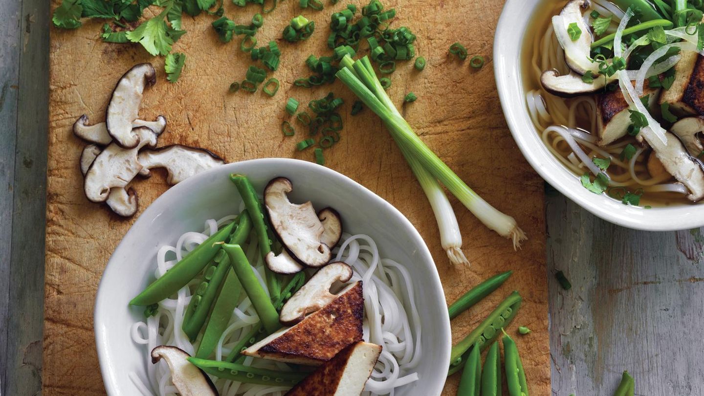 Schnelle vegetarische Pho      Zutaten:  2 cm langes, ungeschältes Stück Ingwer, 2 mittelgroße grüne Zwiebeln, 1 Sternanis (insgesamt 8 robuste Zacken), 3 ¾ cm Zimtstange, 1 oder 2 ganze Gewürznelken, 840 ml bis 1 l natriumarme oder normale Gemüsebrühe, etwa ½ TL feines Meersalz, 150 g getrocknete Reisbandnudeln, 4 Stück scharf angebratener Tofu, 8 Zuckerschoten oder dünne grüne Bohnen, 2 oder 3 frische Pilze (Shiitake, Kräuterseitling oder ähnliche), 2 bis 3 TL normale Sojasauce, etwa ½ TL Zucker oder 1 TL Ahornsirup (optional), 2 EL gehacktes frisches Koriandergrün (nur die feinen oberen Stängel), frisch gemahlener schwarzer Pfeffer (optional)      Zubereitung:  Den Ingwer schälen und in 4 oder 5 Münzen schneiden. Mit der breiten Seite eines Messers oder mit einem Fleischklopfer flach klopfen und beiseitestellen. Die grünen Teile der grünen Zwiebel in dünne Scheiben schneiden (ergibt 2 bis 3 EL) und zum Garnieren beiseitestellen. Restliche Teile in kleinfingerlange Stücke schneiden, zerquetschen, dann in den Ingwer mischen. Sternanis, Zimt und Gewürznelken in einem 3- bis 4-Liter-Topf bei mittlerer Temperatur rösten, bis sie nach 1 bis 2 Minuten duften. Ingwer und grüne Zwiebelteile dazugeben. Etwa 30 Sekunden rühren, bis sie aromatisch sind. Den Topf von der Platte schieben, 15 Sekunden abkühlen lassen, dann die Gemüsebrühe hineingießen. Den Topf wieder auf die Platte stellen, dann 480 ml Wasser und Salz dazugeben. Bei hoher Temperatur aufkochen, dann die Hitze reduzieren und 30 Minuten leicht köcheln lassen. Während die Brühe köchelt, die Reisnudeln in heißem Wasser einweichen, bis sie weich und opak sind. Abgießen, spülen und beiseitestellen. (Siehe Tipps auf Seite 38.) Nun den Tofu zubereiten. (Wenn Sie ihn im Voraus zubereiten, bei Zimmertemperatur wärmen.) Jeden fertigen Tofublock in dünne Scheiben oder in zwei große Dreiecke schneiden und beiseitestellen. Die Zuckerschoten der Länge nach halbieren oder die grünen Bohnen in kurze Teile schneiden, die Pilze in etwa 6 mm dicke Scheiben schneiden. Beiseitestellen und später pochieren. Die fertige Brühe durch ein feines Maschensieb in einen 2- Liter-Topf gießen. Das Sieb mit Musselin auskleiden, damit die Brühe sehr klar wird. Feste Partikel wegwerfen. Das ergibt etwa einen Liter. Mit Sojasauce würzen, um einen kräftigen salzigen Geschmack zu erhalten. Wenn nötig, Zucker (oder Ahornsirup) dazugeben, um die Schärfe zu lindern. Die abgeseihte Brühe bei mittlerer bis hoher Temperatur aufkochen. Die Nudeln 5 bis 60 Sekunden in einem Nudel- oder Maschensieb in die heiße Brühe tauchen, damit sie heiß und weich werden. Dann aus dem Topf nehmen und auf die zwei Schalen verteilen.  Die Temperatur reduzieren, damit die Brühe heiß bleibt, während Sie den Tofu (wenn nötig, zuerst in der Brühe wärmen), die gehackten grünen Zwiebeln, das Koriandergrün und eine Prise Pfeffer dazugeben. Kosten und bei Bedarf zum letzten Mal salzen. Die Brühe erneut aufkochen, in die Schalen schöpfen und servieren. Mit Extras genießen, die Ihnen schmecken.