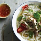 Schnelle Hühnchen-Pho      Zutaten:  2 cm langes Stück Ingwer, 2 mittelgroße grüne Zwiebeln, 1 sehr kleines (15 g) Büschel Koriandergrün, grob gehackt, 1 ½ TL Koriandersamen, 1 ganze Gewürznelke, 840 ml bis 1 Liter natriumarme Hühnerbrühe, 1 Hühnerbrust (180 bis 225 g) oder 1 Schlegel ohne Knochen und Haut, etwa ½ TL feines Meersalz, 150 g getrocknete Reisbandnudeln, 2 bis 3 TL Fischsauce, etwa ½ TL Zucker oder 1 TL Ahornsirup (optional), frisch gemahlener schwarzer Pfeffer (optional)      Zubereitung:  Den Ingwer schälen und in 4 oder 5 Münzen schneiden. Mit einem Fleischklopfer oder der flachen Seite eines Messers flach klopfen und beiseitestellen. Die grünen Teile der grünen Zwiebel in dünne Scheiben schneiden (ergibt 2 bis 3 EL) und zum Garnieren beiseitestellen. Restliche Teile in kleinfingerlange Stücke schneiden, zerquetschen, dann in den Ingwer mischen. Die feinen Stängel des Koriandergrüns grob hacken (ergibt 2 EL) und zum Garnieren beiseitestellen. Die restlichen Stängel beiseitestellen. Koriandersamen und Gewürznelke in einem 3- bis 4-Liter-Topf bei mittlerer Hitze rösten, bis sie nach 1 bis 2 Minuten duften. Ingwer und grüne Zwiebel dazugeben. Etwa 30 Sekunden umrühren, bis die Mischung aromatisch ist. Den Topf von der Platte schieben, 15 Sekunden warten, damit er etwas abkühlt, dann die Brühe hineingießen. Den Topf wieder auf die Platte stellen, dann Wasser, Korianderstängel, Huhn und Salz dazugeben. Bei hoher Temperatur aufkochen, dann die Temperatur reduzieren und die Mischung 30 Minuten leicht köcheln lassen. Während die Brühe köchelt, die Reisnudeln in heißem Wasser einweichen, bis sie weich und opak sind. Abgießen, spülen und beiseitestellen. Nach 5 bis 10 Minuten Köcheln sollte das Huhn fest und durchgegart sein (auf Fingerdruck sollte es nachgeben). Das Huhn in eine Schüssel legen, mit kaltem Wasser übergießen, um das Kochen zu beenden, dann abgießen. Abkühlen lassen, dann in mundgerechte Stücke schneiden oder hacken. Locker zudecken, damit es nicht austrocknet. Wenn die Brühe fertig ist, durch ein feines Maschensieb in einen 2-Liter-Topf gießen. Das Sieb mit Musselin auskleiden, damit die Brühe sehr klar wird. Feste Partikel wegwerfen. Das ergibt etwa 1 Liter. Wenn nötig, mit Fischsauce und Zucker (oder Ahornsirup) würzen, um eine starke pikant-süße Note zu erhalten. Die abgeseihte Brühe bei mittlerer bis hoher Temperatur aufkochen. Die Nudeln 5 bis 60 Sekunden in einem Nudel- oder Maschensieb in die heiße Brühe tauchen, damit sie heiß und weich werden. Dann aus dem Topf nehmen und auf die zwei Schalen verteilen. Die Hitze reduzieren, damit die Brühe heiß bleibt, während Sie das Huhn auf den Nudeln arrangieren und mit den gehackten grünen Zwiebeln, dem Koriandergrün und einer Prise Pfeffer garnieren. Kosten und bei Bedarf zum letzten Mal salzen. Die Brühe erneut aufkochen und in die Schalen schöpfen. Mit Extras genießen, die Ihnen schmecken.