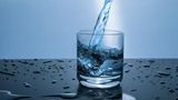 Gesunde Ernährung: Wasser fließt in ein Glas