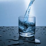Gesunde Ernährung: Wasser fließt in ein Glas