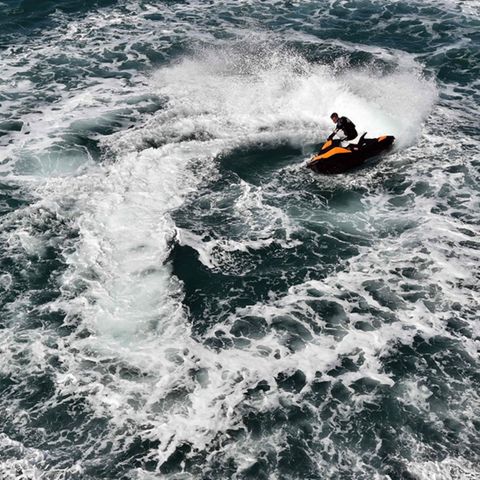 Ein Jet-Ski-Fahrer zieht Kreise auf dem offenen Meer.