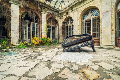 Polen  Drei Klaviere sowie weitere Instrumente fanden sich in diesem verlassenen Palast, der einst einem Musikliebhaber gehört hat. Diese Fotografie zeigt einen eingeknickten Flügel, der in einem überdachten Innenhof liegt. Die davor liegenden Notenblätter wurden vermutlich lange nicht mehr gespielt.