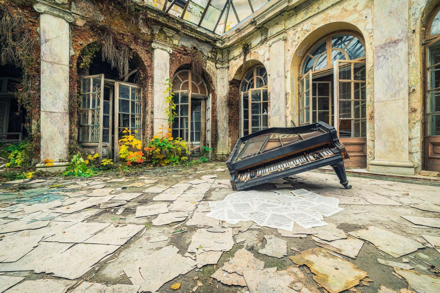 Polen  Drei Klaviere sowie weitere Instrumente fanden sich in diesem verlassenen Palast, der einst einem Musikliebhaber gehört hat. Diese Fotografie zeigt einen eingeknickten Flügel, der in einem überdachten Innenhof liegt. Die davor liegenden Notenblätter wurden vermutlich lange nicht mehr gespielt.