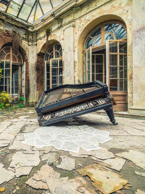 Polen  Drei Klaviere sowie weitere Instrumente fanden sich in diesem verlassenen Palast, der einst einem Musikliebhaber gehört hat. Diese Fotografie zeigt einen eingeknickten Flügel, der in einem überdachten Innenhof liegt. Die davor liegenden Notenblätter wurden vermutlich lange nicht mehr gespielt.