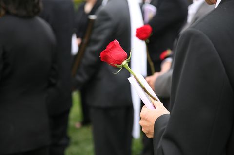 Mann auf Beerdigung mit Rose