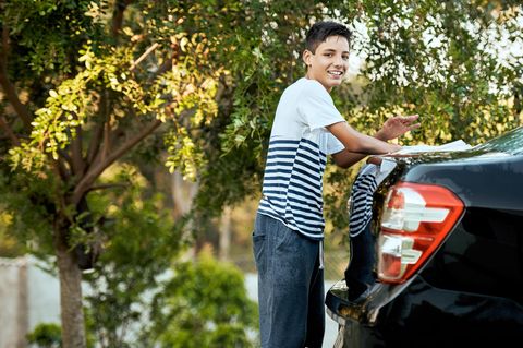 Junge putzt ein Auto