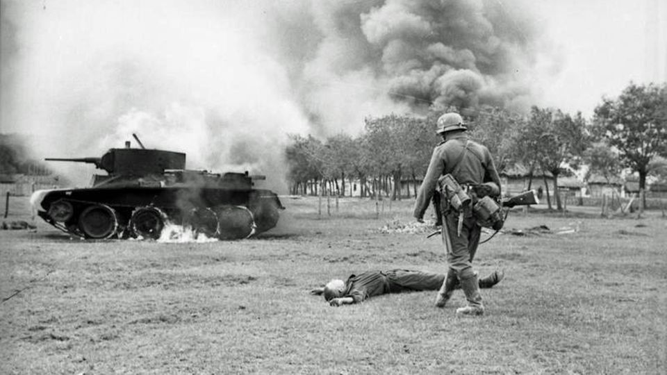 Toter Rotarmist vor seinem brennenden Panzer.