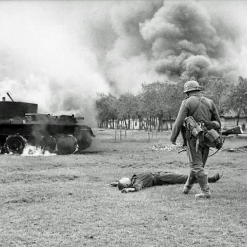 Toter Rotarmist vor seinem brennenden Panzer.