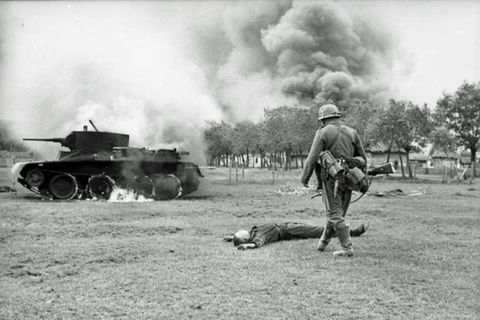 Toter Rotarmist vor seinem brennenden Panzer.