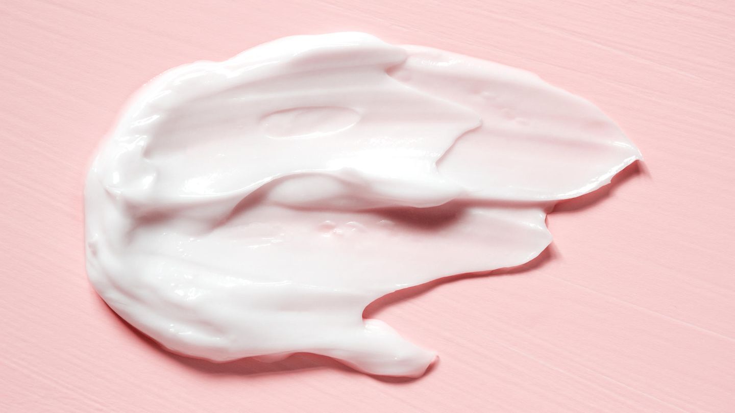 Klecks von Kosmetikcreme auf rosa Oberfläche