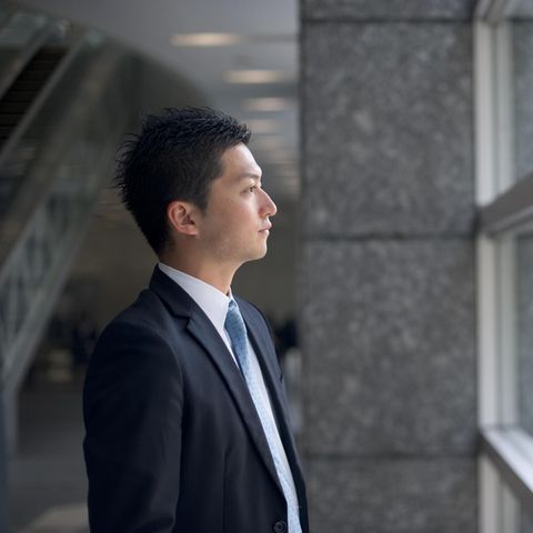 Ein Japanischer Geschäftsmann schaut aus dem Fenster