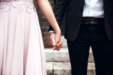 Ein Hochzeitspaar hält Händchen.