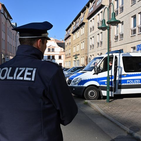 Ein Polizeifahrzeug steht in der Cottbusser Mühlenstraße, wo ein stadtbekannter Neonazi einen Klamottenladen betreibt.