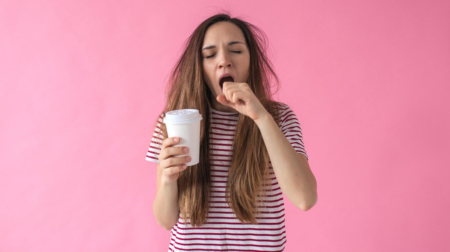 Müdes Mädchen mit Kaffeebecher