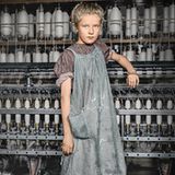 Ein junges Mädchen, barfuß an einer Maschine