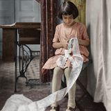 Ein Mädchen schneidet mit einer kleinen Schere Spitze zu