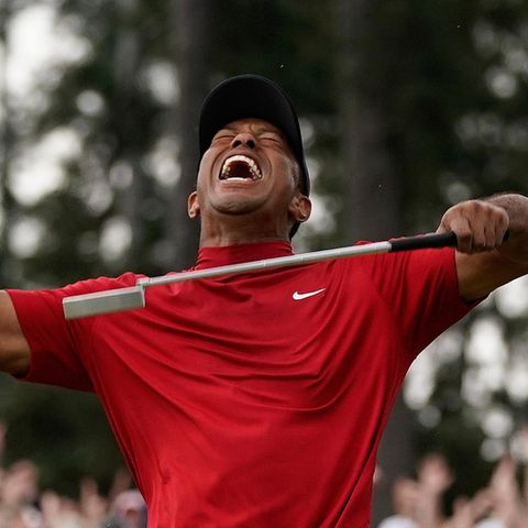 Tiger Woods reißt jubelnd den Kopf nach hinten und ballt die rechte Faust. In der linken hält er einen Golfschläger.
