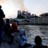 Menschen versammeln sich, verfolgen das Geschehen vom Seine-Ufer aus.