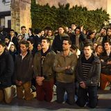 Singen, beten, zusammenstehen und das Entsetzen teilen - zahlreiche Menschen beobachten den Brand aus der Entfernung.