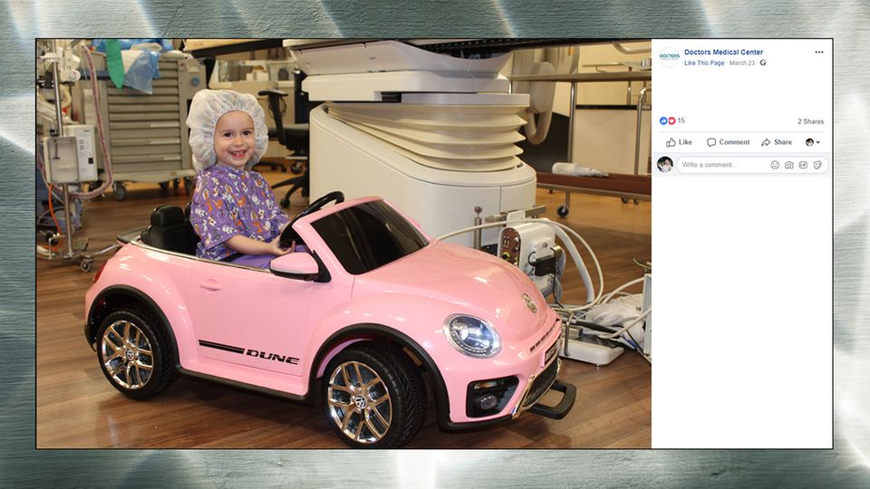 Kleinkind fährt einen pinken Spielzeug-VW-Beetle in den Operationssaal.