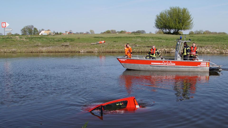 Rettungskräfte bergen ein Auto aus dem Hafenbecken in Bleckede