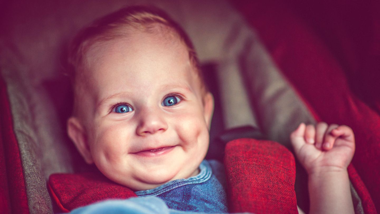 WHO: Ein Baby sitzt im Kinderwagen und lacht
