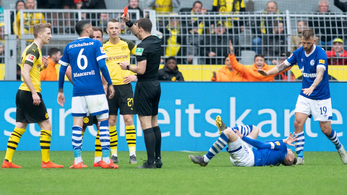 Schiedsrichter Felix Zwayer (m.) zeigt Dortmunds Marco Reus (l.) die rote Karte