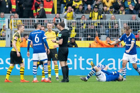 Schiedsrichter Felix Zwayer (m.) zeigt Dortmunds Marco Reus (l.) die rote Karte