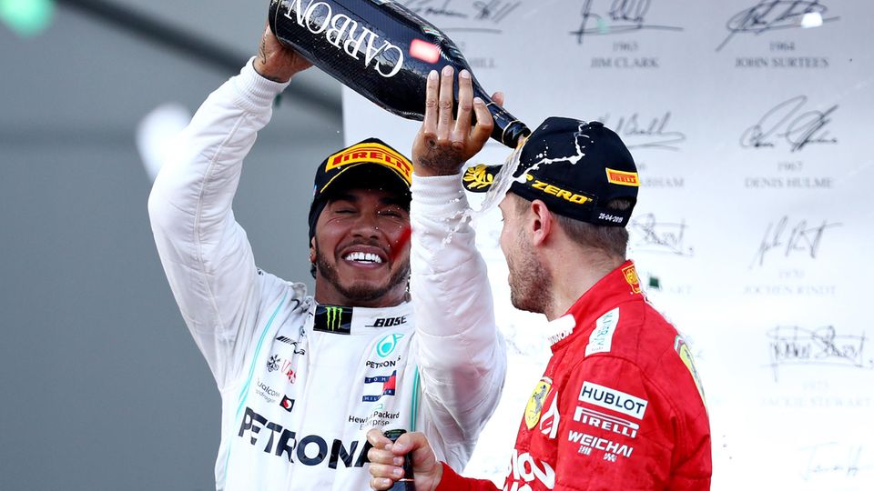 Lewis Hamilton schüttet Sebastian Vettel Schampus auf dem Podium in Bahu über den Kopf