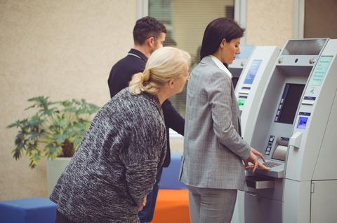 Leute stehen an am Bankautomat