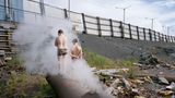 Zwei Jungen schlendern über ein verlassenes Flussufer. 