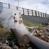 Zwei Jungen schlendern über ein verlassenes Flussufer. 