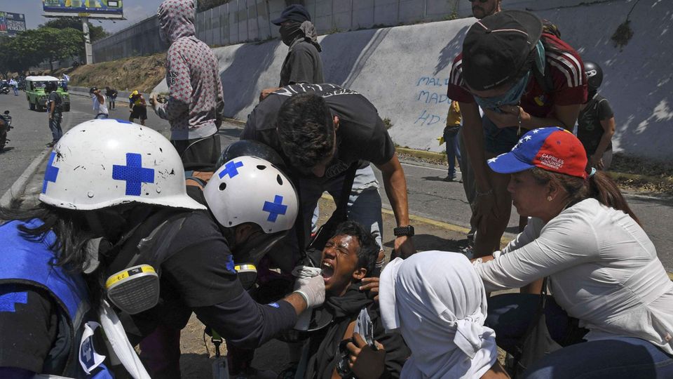 Ein oppositioneller Demonstrant wird nach dem Einsatz von Tränengas medizinisch versorgt
