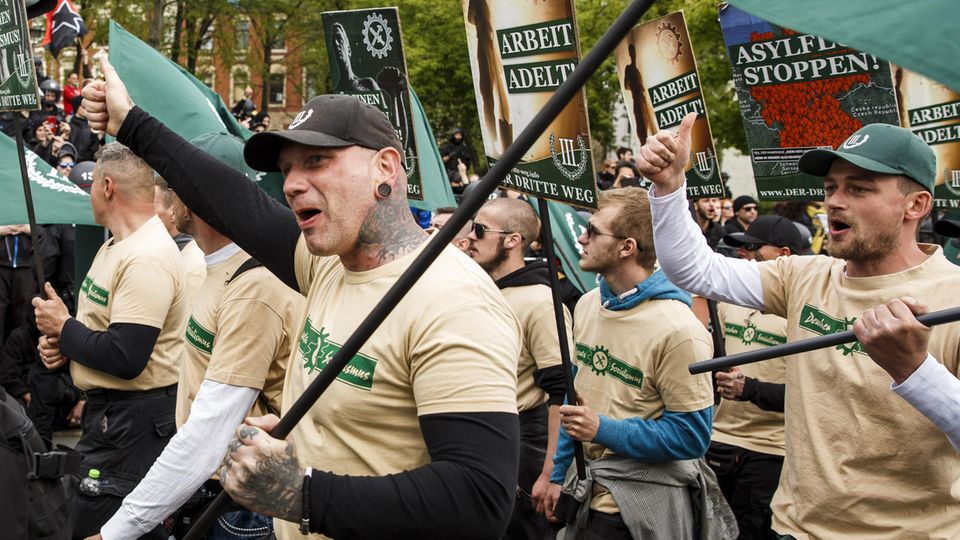 Durchtrainierte und tätowierte Männer demonstrieren in einheitlichen T-Shirts der Partei "Der 3. Weg" in Plauen