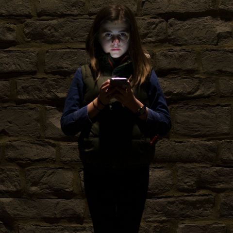 Mädchen im Dunkeln mit Smartphone