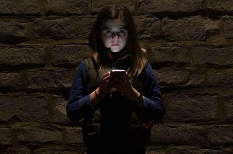 Mädchen im Dunkeln mit Smartphone