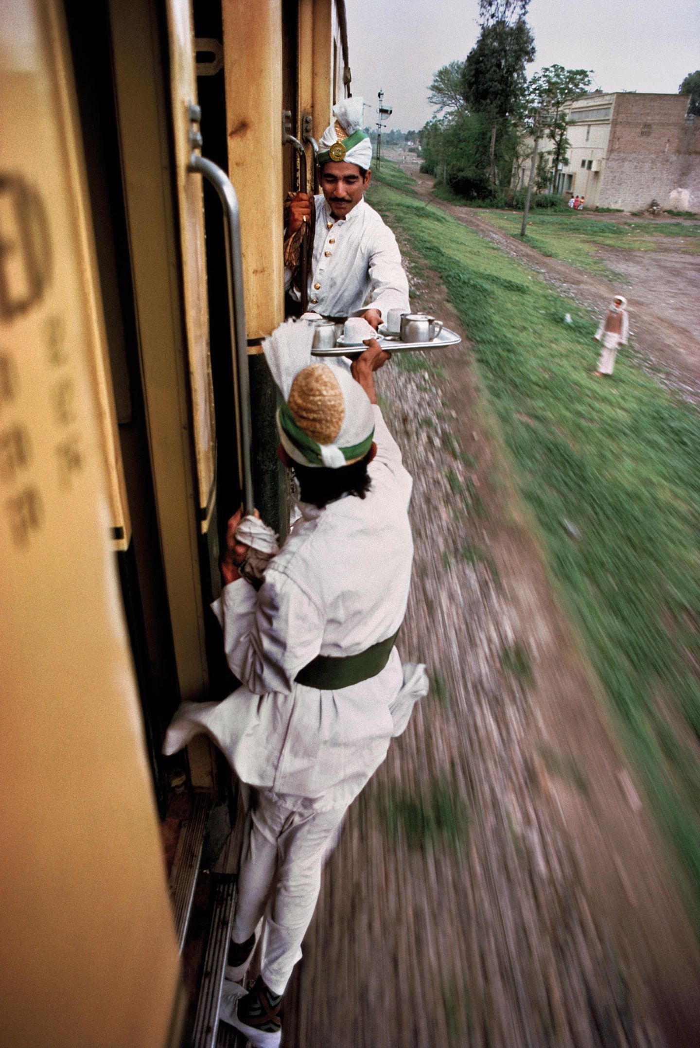 Pakistan, 1983. McCurry reiste kreuz und quer durch die Welt – per Schiff, zu Fuß, mit Kamelen. Als besonders faszinierend empfand der Fotograf aber wohl das Reisen mit der Eisenbahn  – warum, lässt sich auch auf diesem Bild unschwer erkennen. Eine seine bekannteren Arbeiten trägt den Titel "Indien mit der Eisenbahn", für die er allerlei Szenen einfing. Schwester Bonnie erklärt: "Der Reiz der Bahn war leicht zu erkennen. Steve hatte seit seinen ersten Tagen in Indien die Züge und Bahnstationen als eine Art Mikrokosmos erkannt, in dem jeder Aspekt des Landes, ja des gesamten menschlichen Lebens zutage trat". 