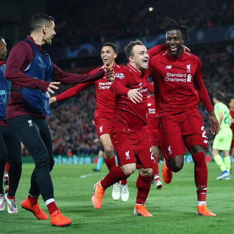 Drei Spieler in Trikots des FC Liverpool laufen jubelnd auf zwei Spieler in Trainingsanzügen zu