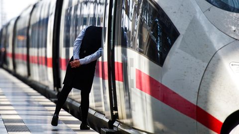 Eine Zugbegleiterin blickt am Hauptbahnhof von Frankfurt am Main durch die offene Tür eines InterCityExpress