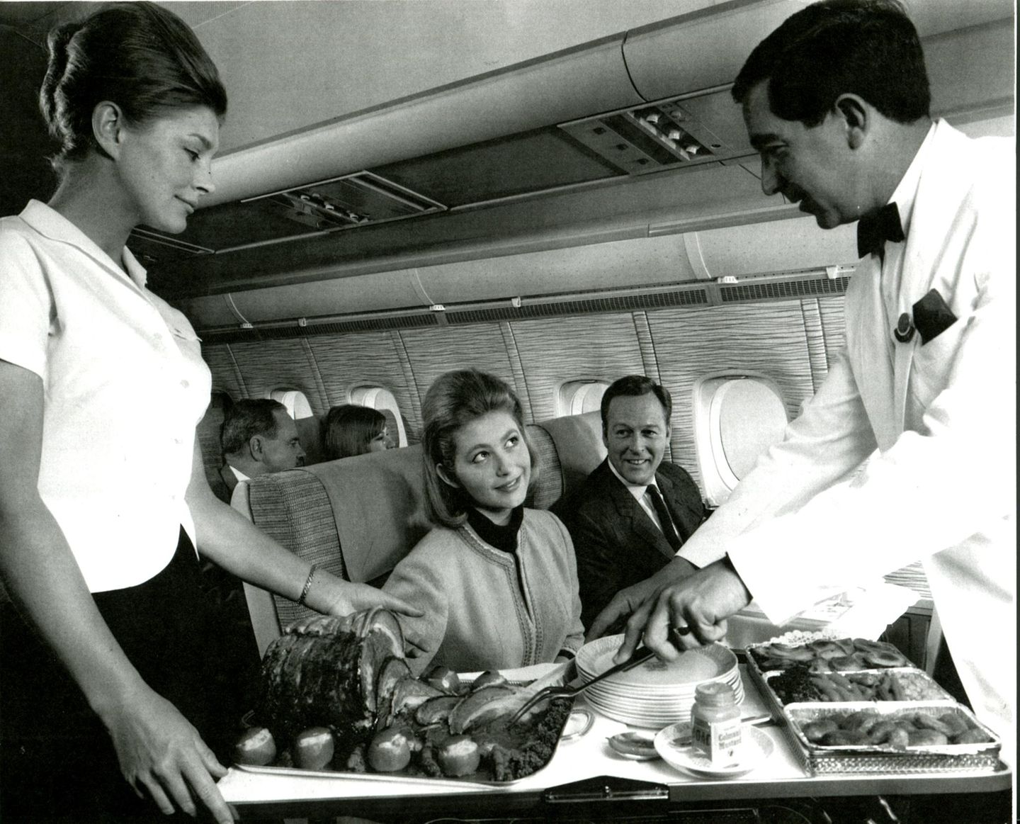 First Class Cabin Service in den späten 1960er Jahren: An Bord des vierstrahligen Langstreckenflugzeugs vom Typ Vickers VC-10 der British Overseas Airways Corporation (BOAC) wird vom Rollwagen serviert.