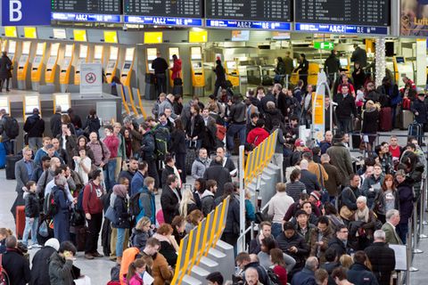 Passagiere warten auf dem Frankfurter Flughafen an Check-in-Schaltern
