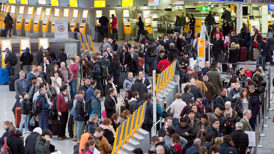 Passagiere warten auf dem Frankfurter Flughafen an Check-in-Schaltern Passagiere warten auf dem Frankfurter Flughafen an Check-in-Schaltern