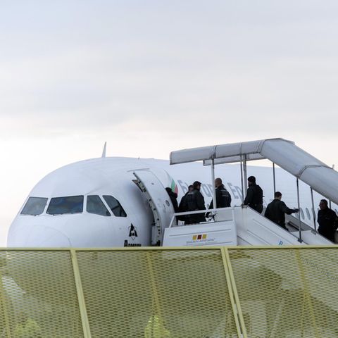 Abgelehnte Asylbewerber steigen an Bord eines Abschiebefluges