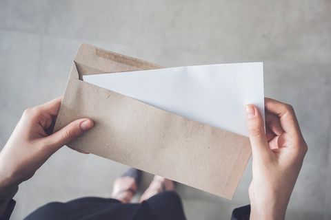 Zwei Frauenhände öffnen einen Brief