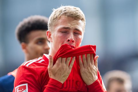 HSV-Spieler Jann-Fiete Arp zieht den Saum seines roten HSV-Trikots mit beiden Händen zum Gesicht