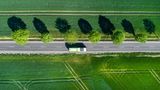 Bus in grüner Landschaft aus der Vogelperspektive.