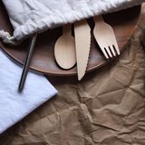 Besteck aus Bambus und ein Metallstrohhalm in einem Stoffbeutel.